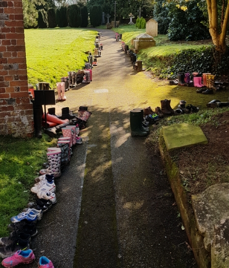 [Children's boots and shoes line the path after walking to St Mary's]